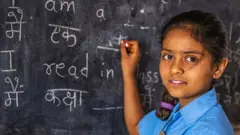 ब्लैकबोर्ड पर लिखती बच्ची