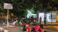 ပလက်ဖောင်းပေါ်အိပ်ပြီးစောင့်နေတဲ့ အထည်ချုပ် က အမျိုးသမီးလုပ်သားများ