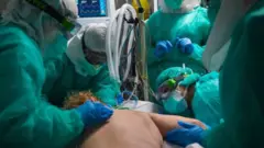 فريق يعنى بمريض منبطح على بطنه