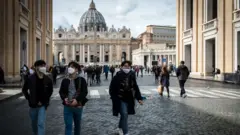 italya'da maske takmış turistler