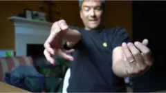 Xavier Alford showing how is hands are becoming paralysed