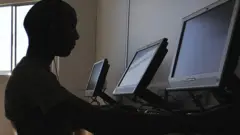 ኮምፒውተር ላይ የተቀመጠ ሰው