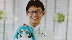 Foto de Akihito Kondo com uma boneca Miku