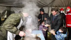 göçmenlere sıcak yemek dağıtılırken