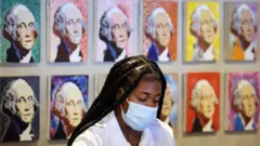 Empleada de un hotel en Washington utilizando la mascarilla