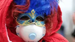 Masked carnival reveller wears protective face mask at Venice Carnival, which the last two days of, as well as Sunday night"s festivities, have been cancelled because of an outbreak of coronavirus, in Venice, Italy February 23, 2020