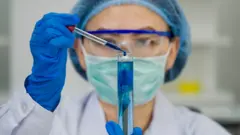 Investigadora examinando una pipeta en el laboratorio