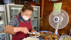 Japanese cafe owner serves lunch.