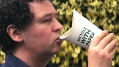 두걸쇼 기자가 뚜껑 없는 컵으로 커피를 마시고 있다