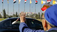 بغداد - البابا يحيي مستقبليه اثناء توجه موكبه من مطار بغداد الى القصر الجمهوري