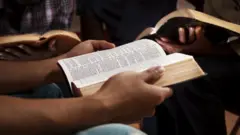 Uma pessoa segurando uma Bíblia aberta
