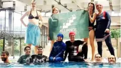 Members of the campaign group Citizen Alliance of Grenoble protest at a community pool in Grenoble, France