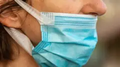 Maske takarken burnunu açıkta bırakmış bir kişi