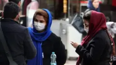 إيرانيون يضعون كمامات