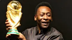 نجم كرة القدم البرازيلي بيليه يحمل كأس العالم خلال عرضه في ريو دي جانيرو، البرازيل في 6 فبراير 2010.