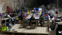 люди сидят за столом в пещере