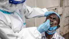 Un homme subit un prélèvement nasal au Kenya