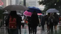 Pessoas caminhando na avenida Paulistadownload do aplicativo betnacionaldiadownload do aplicativo betnacionalChuvadownload do aplicativo betnacionalSão Paulo