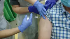 A volunteer receives the vaccine