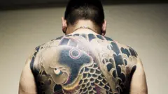 Hombre con tatuajes en su espalda