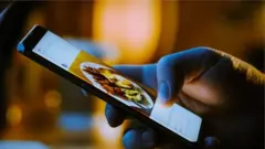 celular com imagem de um prato de comida na tela