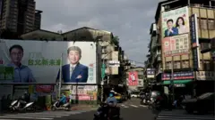 Traffic can be seen with the backdrop of election campaign posters put up in Taipei, Taiwan, November 14, 2022