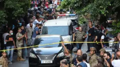 Vehicles are seen outside the Federal bank of Lebanon, after people who were held hostages exited the bank, in Hamra, Lebanon, August 11, 2022. REUTERS/Mohamed Azakir