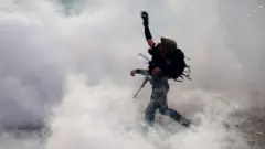 Протестующий бросает камень