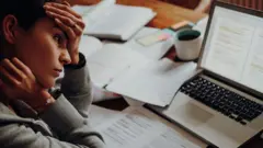 Mulher cansada em frente a computador