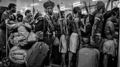 Membros da comunidade Munduruku fazem fila para embarcar em avião no Aeroporto de Altamira, no Pará, Brasil, em 14 de junho de 2013