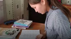 китеп окуп олтурган кыз
