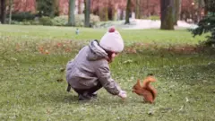 Una niña y una ardilla.