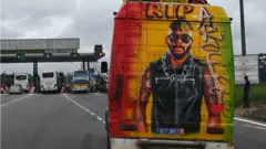 Un mini bus avec des graffitis représentant le DJ ivoirien Ange Didier Houon alias DJ Arafat sur l'autoroute près d'Abidjan.
