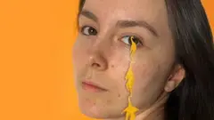 Chloe with acrylic creatures dangling from her eyelash which were coloured using bacteria