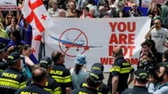 People protest the resumption of air links with Russia during the arrival of the first direct flight of the Russian airline Azimuth, from Moscow to Tbilisi International Airport, in Tbilisi, Georgia