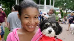 Une femme tenant un chien dans ses bras