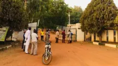 Some pipo in front of di College of Forestry gate