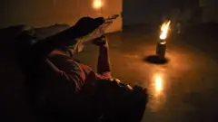 hombre lee a la luz de un mechero