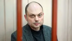 Russian opposition activist Vladimir Kara-Murza sits on a bench inside a defendants' cage during a hearing at the Basmanny court in Moscow on October 10, 2022