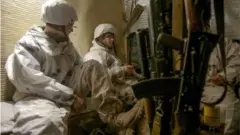 جنديان أوكرانيان يرابطان عند خطوط المواجهة في شرقي أوكرانيا.