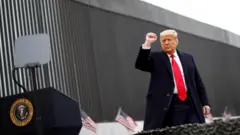 Donald Trump saat mengunjungi tembok pembatasan di Texas