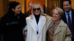 トランプ前大統領に巨額の損害賠償が命令された名誉毀損裁判を終えて、ニューヨークの連邦地裁を出る原告のE・ジーン・キャロルさん（中央）と弁護士たち（26日、ニューヨーク）