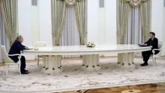 Putin ve Macron uzun masa etrafında