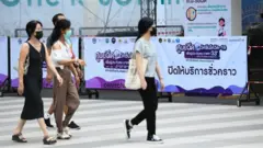 คนเดินผ่านศูนย์ฉีดวัคซีน