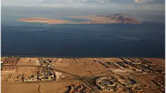 صورة من نافذة طائرة تظهر جزيرتي تيران (المقدمة) وصنافير (الخلفية) في البحر الأحمر في مضيق تيران بين شبه جزيرة سيناء المصرية والمملكة العربية السعودية