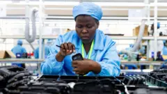 Ugandan factory workers assemble mobile phone cases