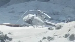 Helicopter covered in ash on White Island, 9 December