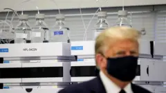 ترامب يرتدي كمامة داخل معمل