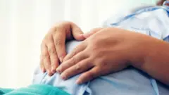 ผู้หญิงท้องเอามือจับท้อง