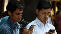 મોબઇલથી જોતા યુવાનો